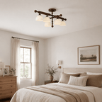 Wood bars and frosted shades of this Clérachic semi flush light, above a bedroom with a pale bed and a chest of drawers.