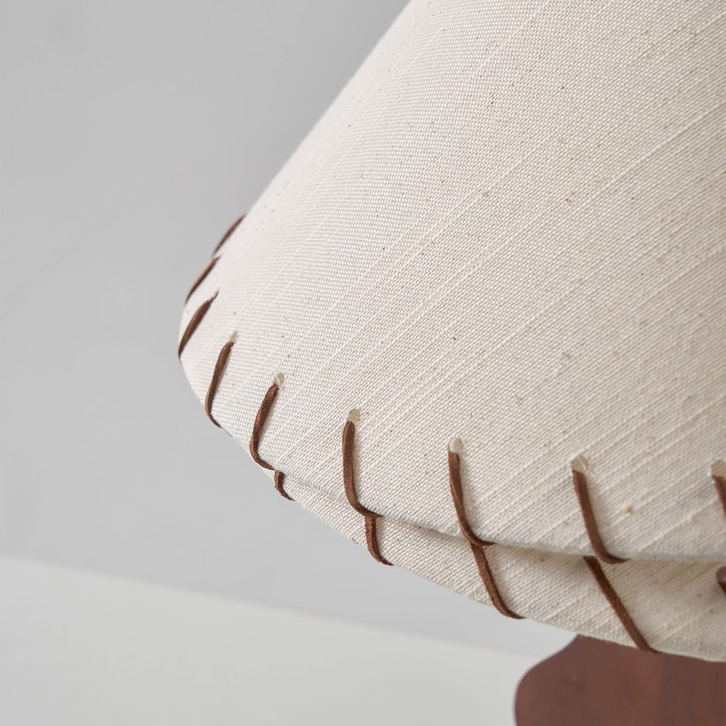 Close view of the textured linen weave and leather stitching on the lower tier of this Clérachic lamp shade.