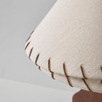 Close view of the textured linen weave and leather stitching on the lower tier of this Clérachic lamp shade.