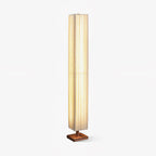 Tall square pleated fabric floor lamp from Clérachic on a small walnut wood base, shown on a plain white background.