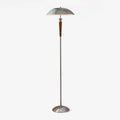 A Clérachic floor lamp with a domed chrome shade, walnut tapered stem and chrome base, lit on a plain white backdrop.