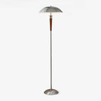 A Clérachic floor lamp with a domed chrome shade, walnut tapered stem and chrome base, lit on a plain white backdrop.