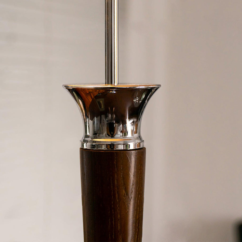 Close view of the flared chrome collar where the walnut stem of this Clérachic floor lamp meets the slim chrome pole.