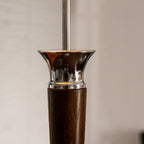 Close view of the flared chrome collar where the walnut stem of this Clérachic floor lamp meets the slim chrome pole.