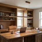 Clérachic walnut bar pendant above a rustic wood desk with a laptop, in front of a built-in bookcase and a window.