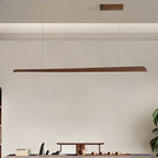 Long walnut bar pendant with a wooden ceiling plate, lit underneath, above a tea table in a pale room, from Clérachic.