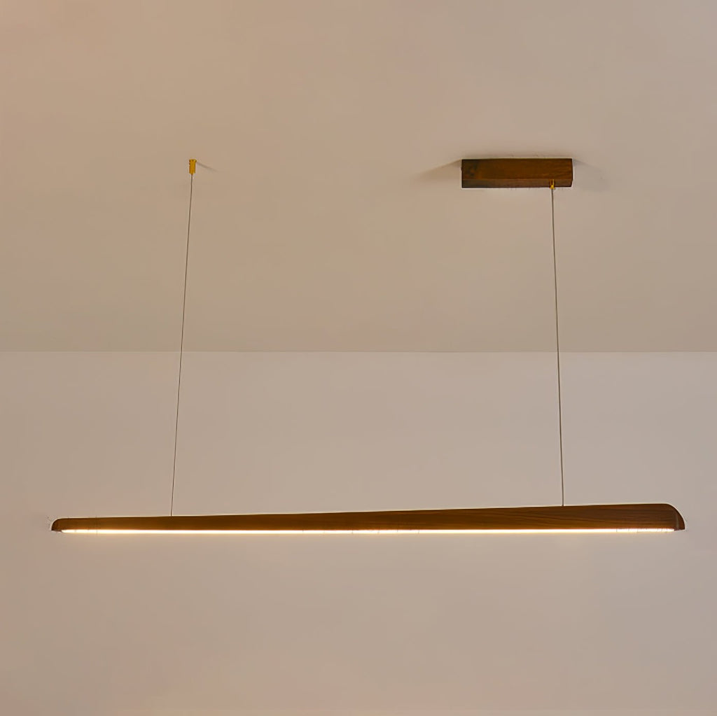 Clérachic walnut bar pendant lit with a warm amber glow along its underside, hung from a wooden ceiling plate.