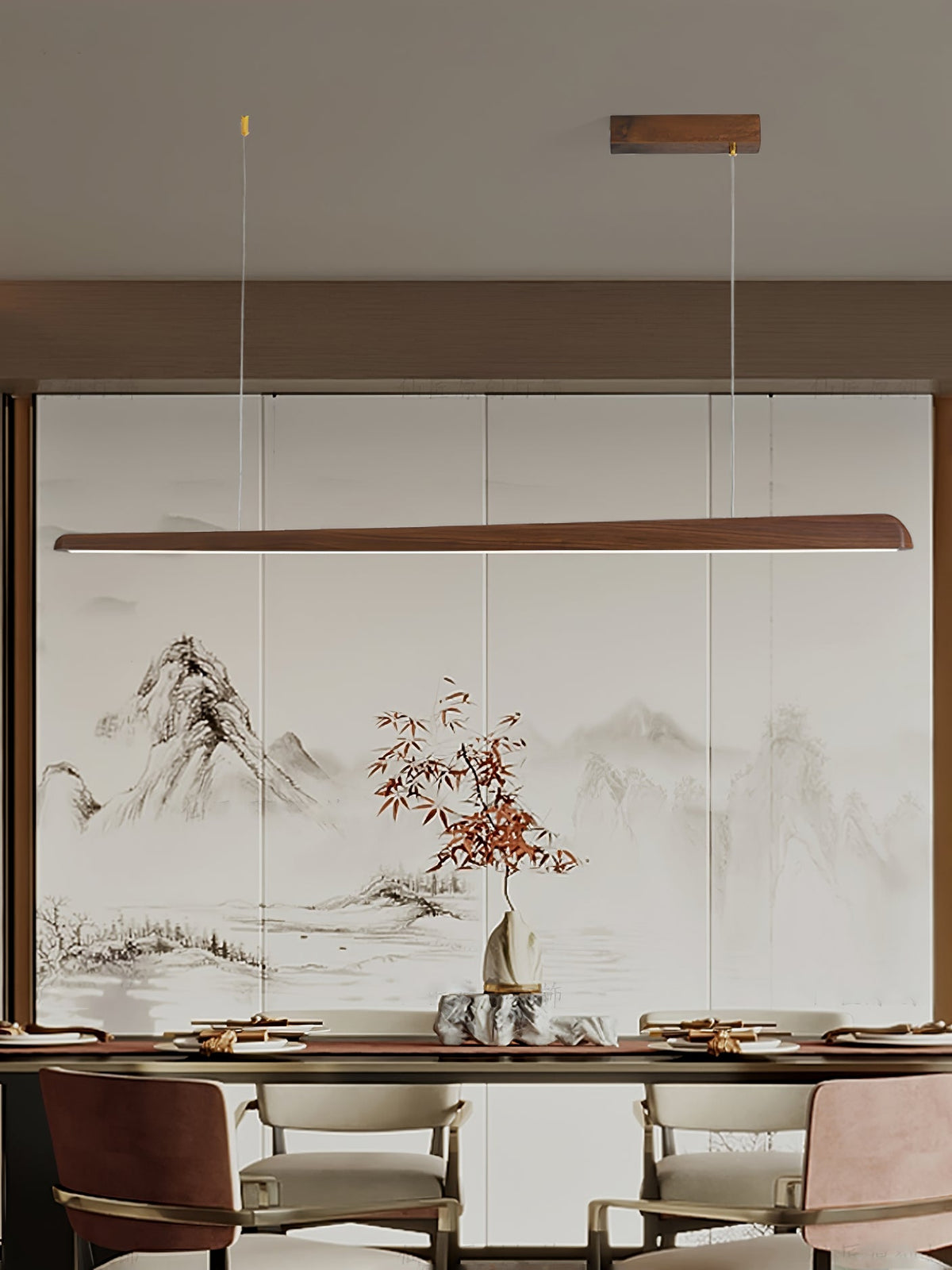 Walnut bar pendant above a dining table and cream chairs, in front of a painted mountain landscape panel, from Clérachic.