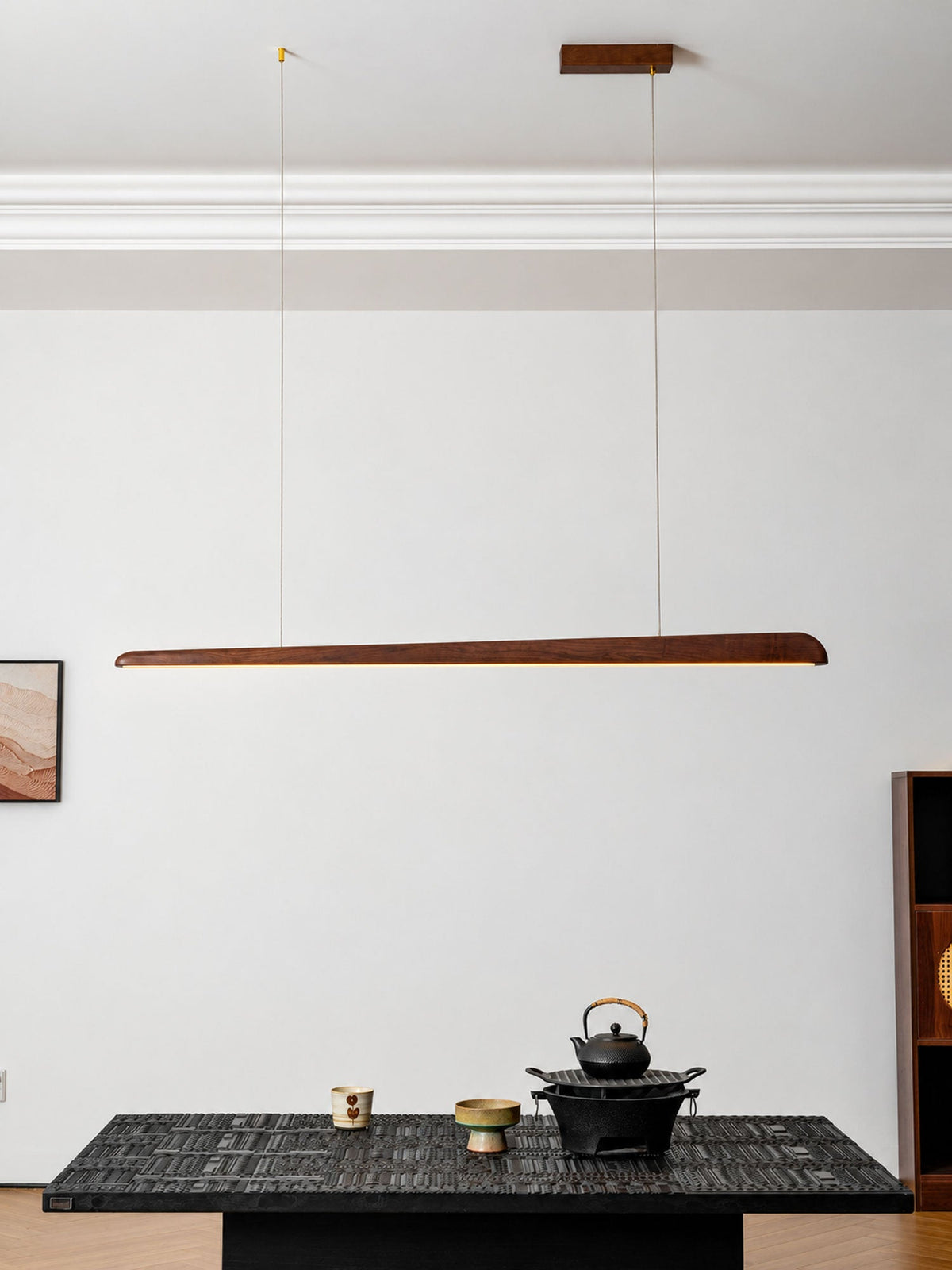 Clérachic walnut bar pendant on two wires from a wooden ceiling plate, above a low black table with a teapot.