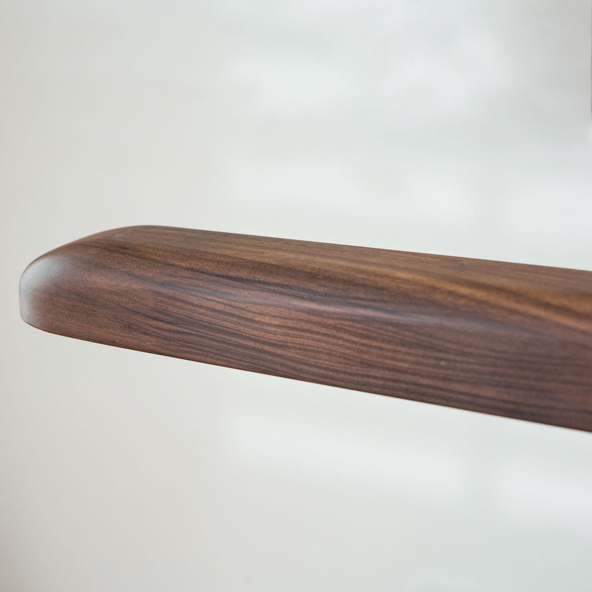 Close view of the rounded end and grain of the solid walnut body on this Clérachic pendant.