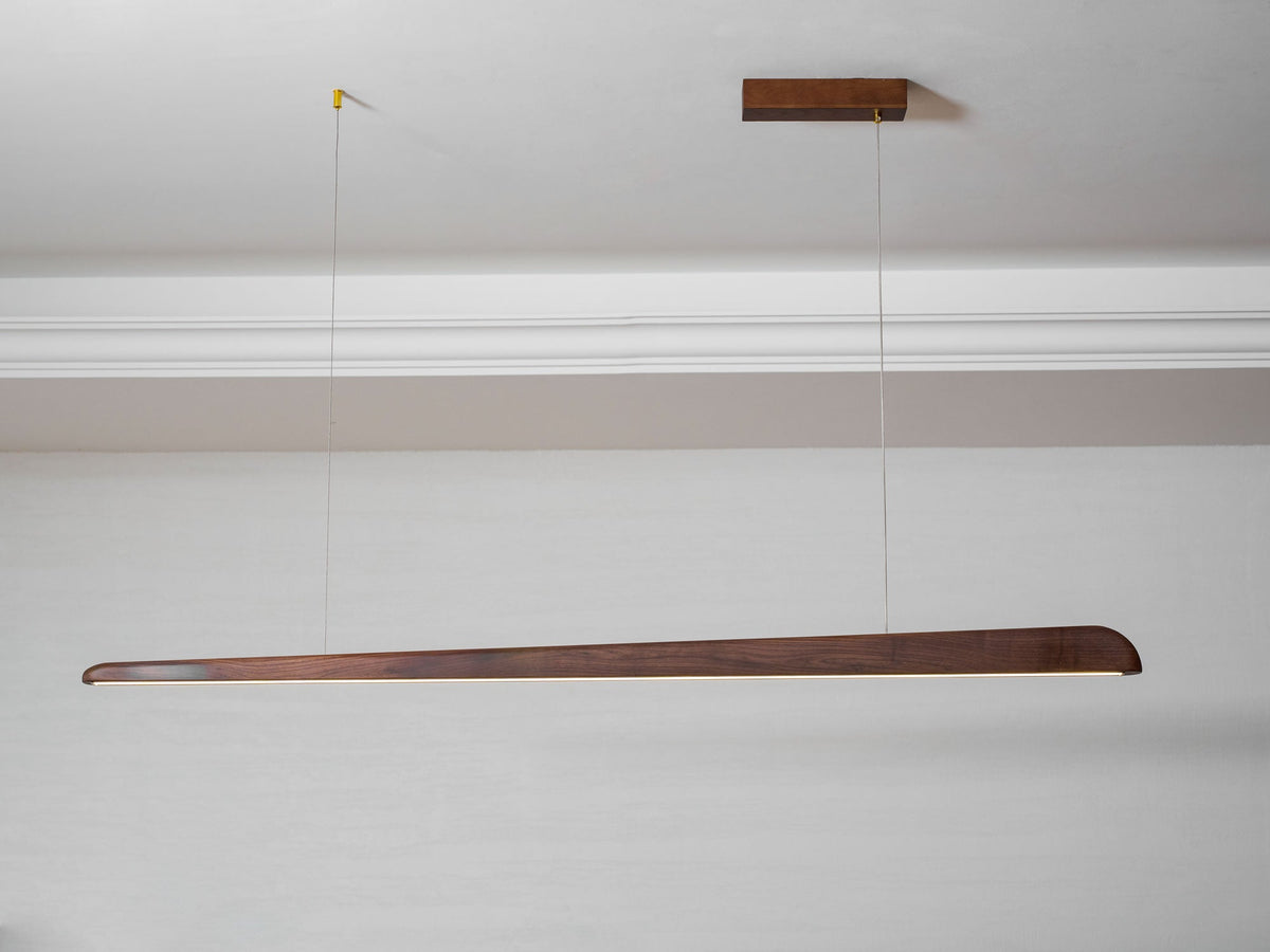 Clérachic walnut bar pendant hung from a small wooden ceiling plate beneath white cornice moulding.