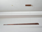 Walnut bar pendant hung from a wooden ceiling plate below a white cornice, seen from a distance, from Clérachic.