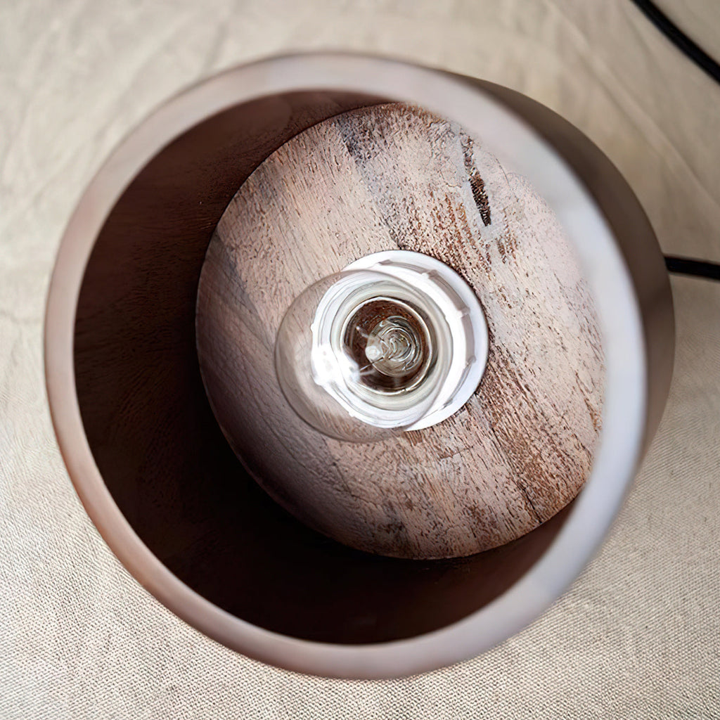 Looking up into this Clérachic pendant from below: a bare filament bulb sits on a round walnut disc inside the shade.