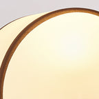 Close view of the half-round white fabric shade and its dark piped edge on this Clérachic table lamp.