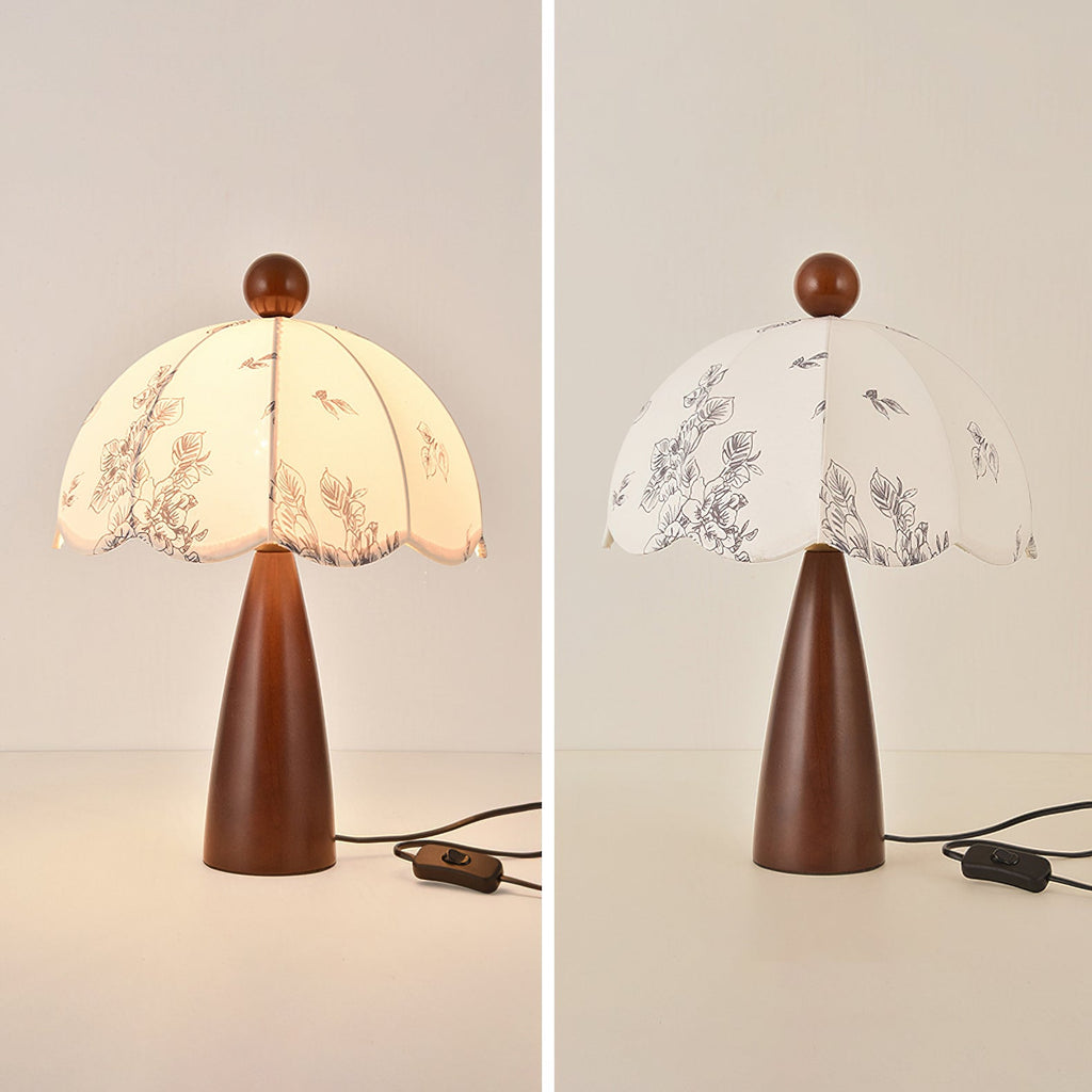 Two views of this Clérachic lamp with a tapered wooden base, one lit and one unlit, on a pale backdrop with its switch cord.