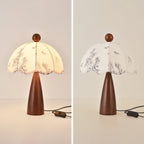 Two views of this Clérachic lamp with a tapered wooden base, one lit and one unlit, on a pale backdrop with its switch cord.