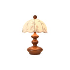 This Clérachic table lamp with a rounded, tiered wooden base and a scalloped floral shade, on a white background.
