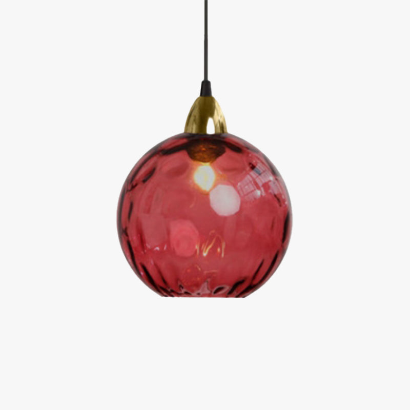 Single crimson Clérachic water ripple glass globe pendant on a white studio ground, its dimpled surface lit from within.
