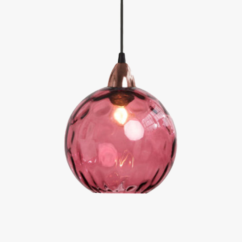 Studio shot of a raspberry-pink Clérachic water ripple glass globe pendant, a copper socket cup at the neck of the dimpled globe.