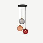 Clérachic water-ripple glass pendant in the red colourway, smoke, blush and deep red globes staggered under a round black canopy.