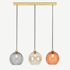 Clérachic ripple-glass pendant on its polished brass bar, smoke, champagne and orange globes hanging level on black cords.