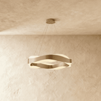 Clérachic round wavy chandelier in brushed gold, hung on four fine cables below a textured plaster ceiling.
