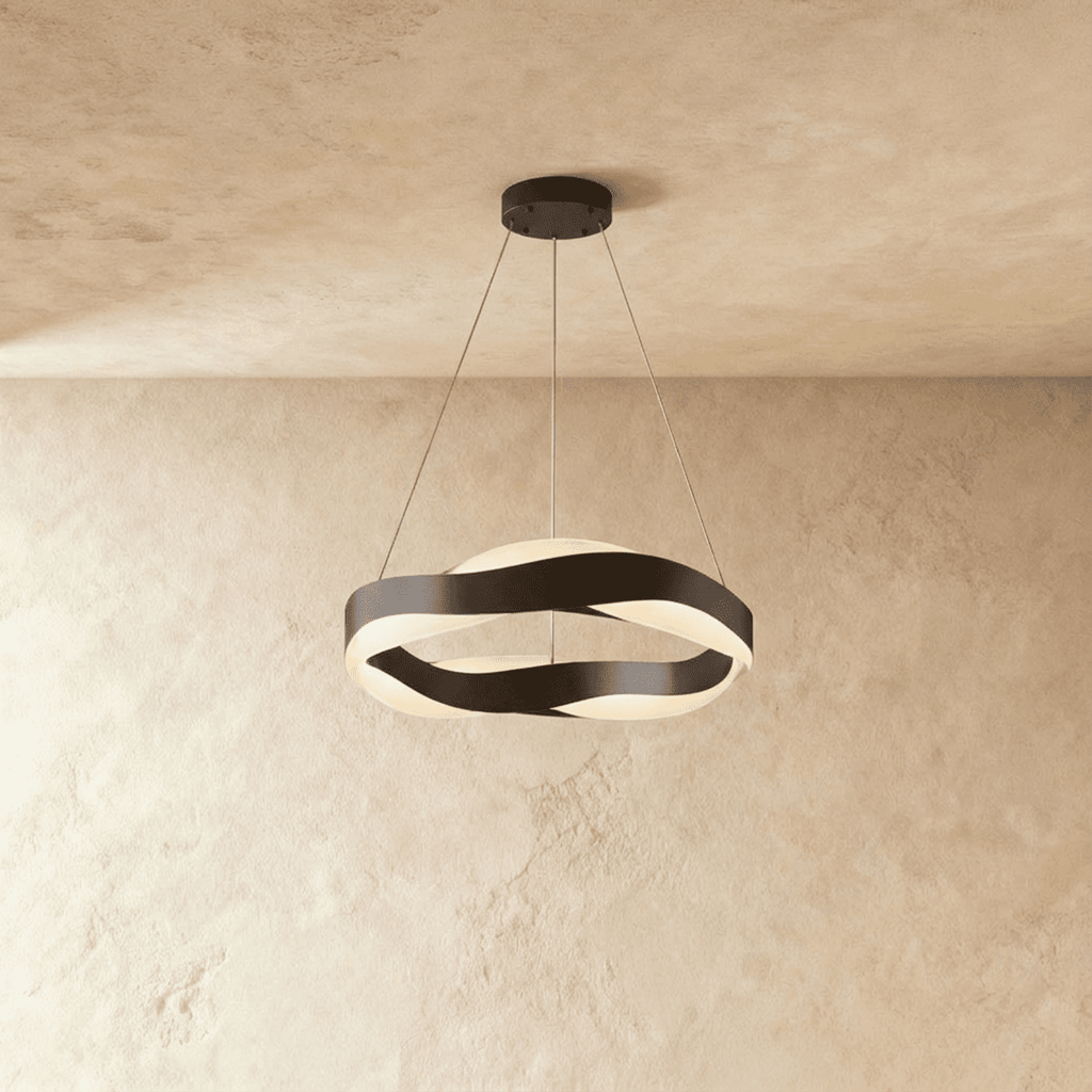 Clérachic round wave chandelier with black twisting bands and a black ceiling plate, lit on a warm plaster wall.