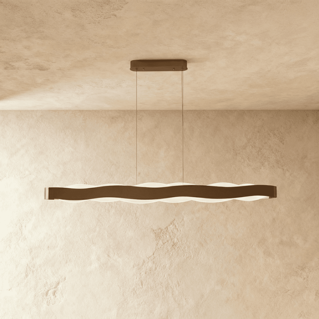 Clérachic longer linear wave pendant in a bronze-toned finish, its frosted light glowing under the wavy band.