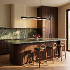 Clérachic black linear wave pendant over a green marble kitchen island with wooden stools and walnut cabinets.