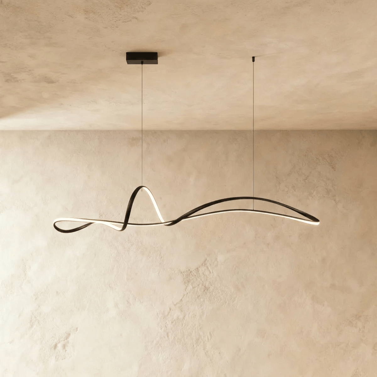 Clérachic black sculptural ribbon pendant with a glowing LED edge, hung from a small rectangular canopy against plaster.