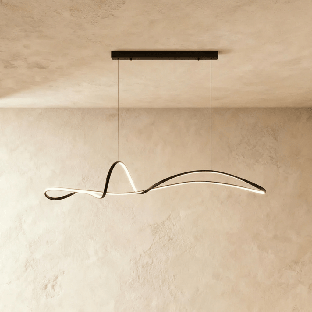 Clérachic black wave-like ribbon pendant with a warm LED edge, suspended from a long black horizontal bar canopy.