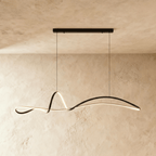 Clérachic longer black ribbon pendant glowing along its curve, hung from a horizontal bar canopy against a plaster wall.