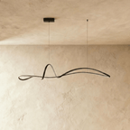 Clérachic black ribbon pendant switched off, showing its slim iron curve and small rectangular canopy against plaster.