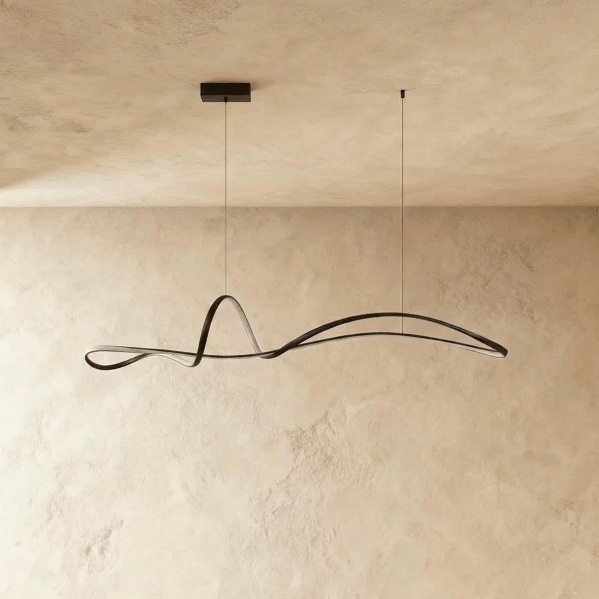 Clérachic black ribbon pendant switched off, showing its slim iron curve and small rectangular canopy against plaster.