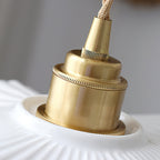 Close view of the brass lamp holder and knurled ring where the twisted cord meets the white ceramic shade of this Clérachic pendant.