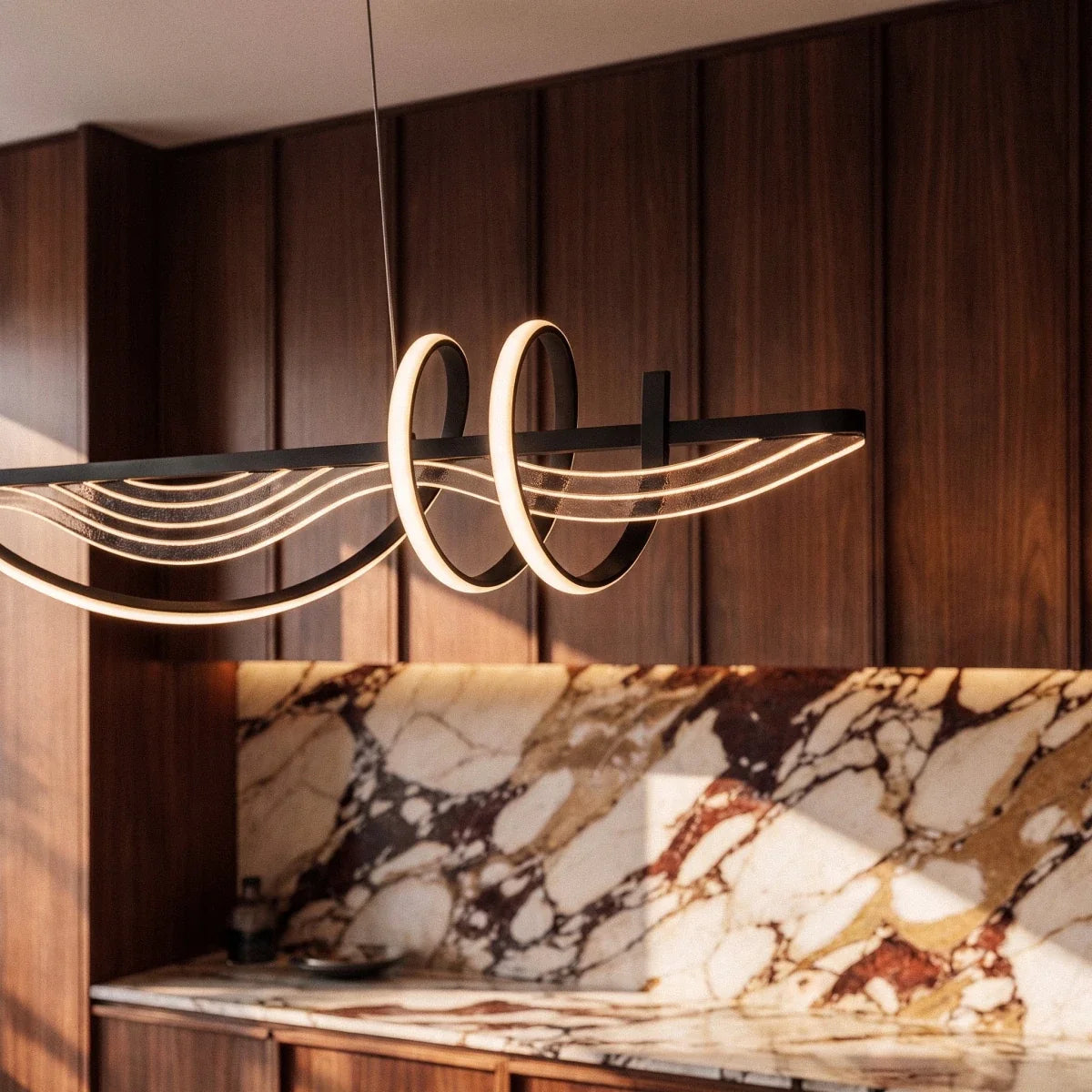 Clérachic black LED pendant close-up, the lit double loop and fine acrylic wave lines against walnut panels and marble.
