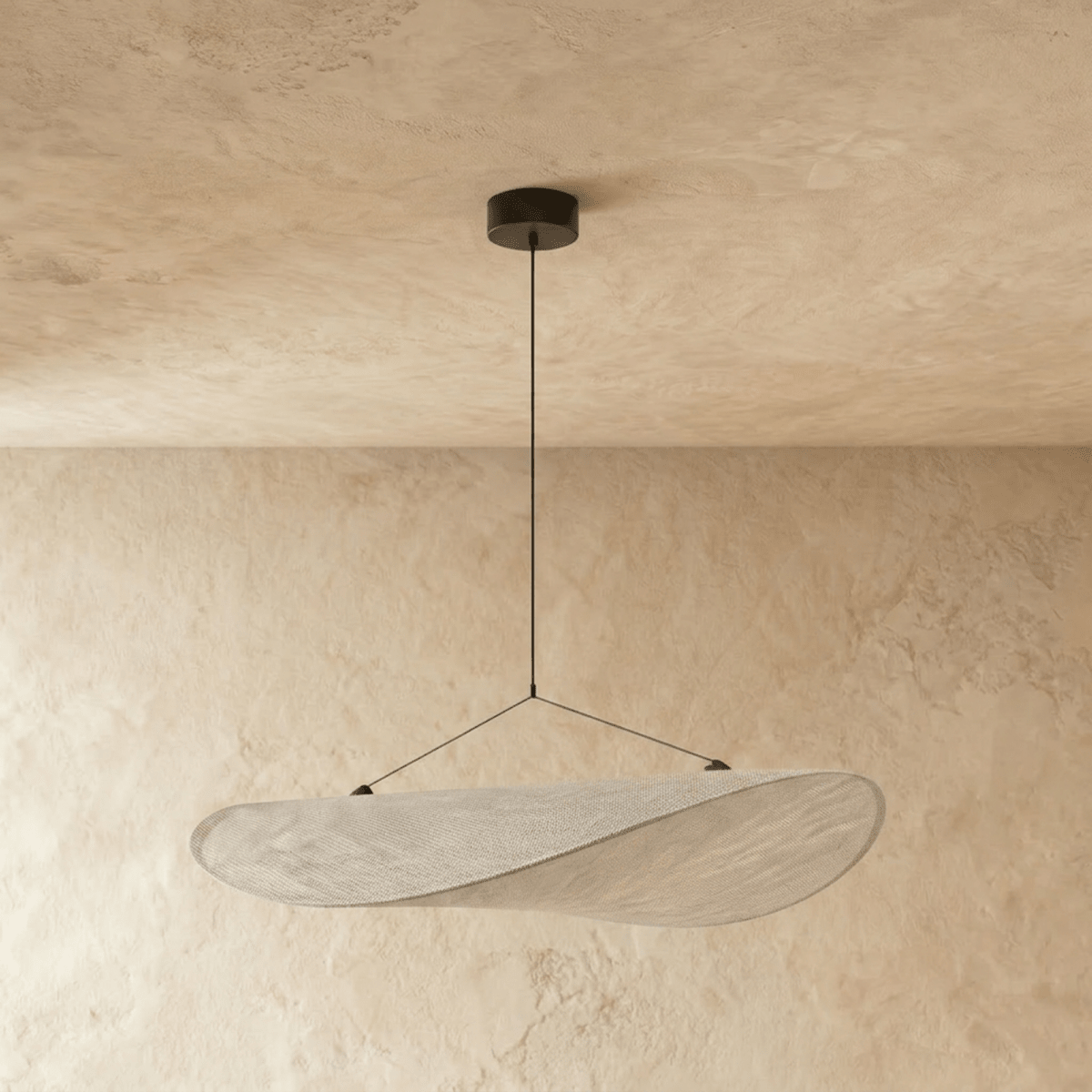 Clérachic leaf-shaped pendant in an unlit white woven-look shade on thin wires and a black ceiling rose, against limewash plaster walls.