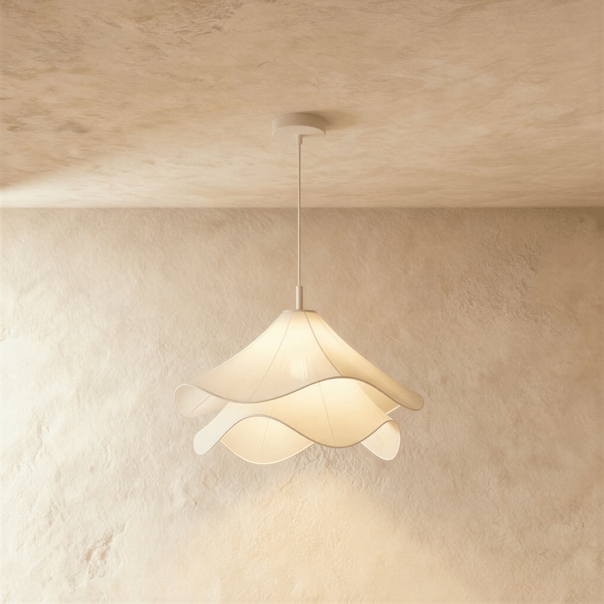 Clérachic pendant light with layered wave-edged white fabric shades on a slim white stem, against a limewash wall.