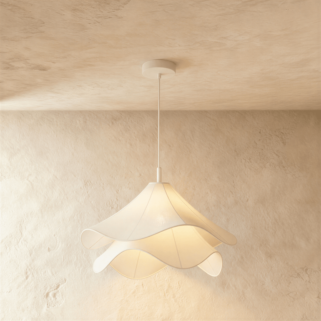 Clérachic wave-edged fabric pendant seen close up, two tiers of white cloth diffusing warm light below a white canopy.