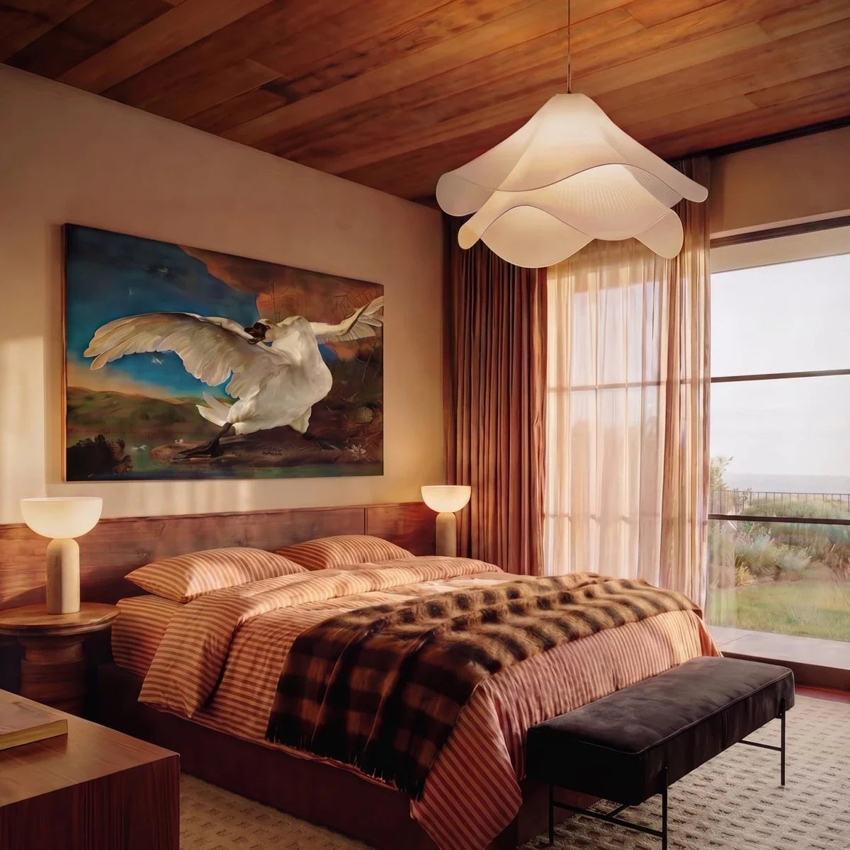 Clérachic white fabric pendant with rippled layers above a bed, with timber ceiling, rust curtains and a large painting.