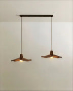 Clérachic double pendant: two wavy wooden shades hanging from one long dark bar canopy, shown in a plain studio.