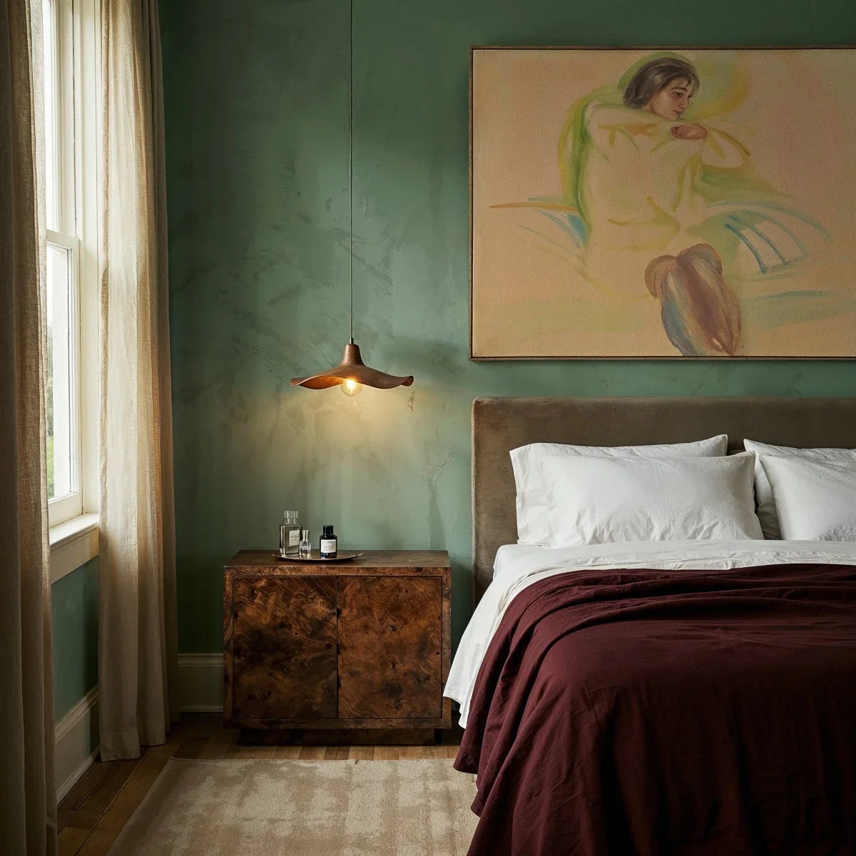 Clérachic single wavy wooden pendant hanging beside the bed in a bedroom with sage green walls and a burr-wood nightstand.