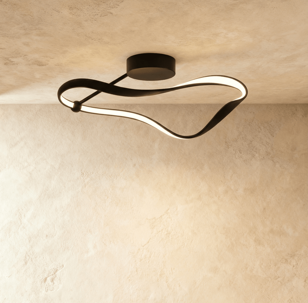 Clérachic black aluminium ceiling light shaped as a twisting ribbon with a warm glowing LED band, on a round canopy against limewash.