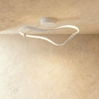 Clérachic white ceiling light formed as a twisting ribbon of aluminium with a soft glowing LED edge, mounted on a limewashed ceiling.