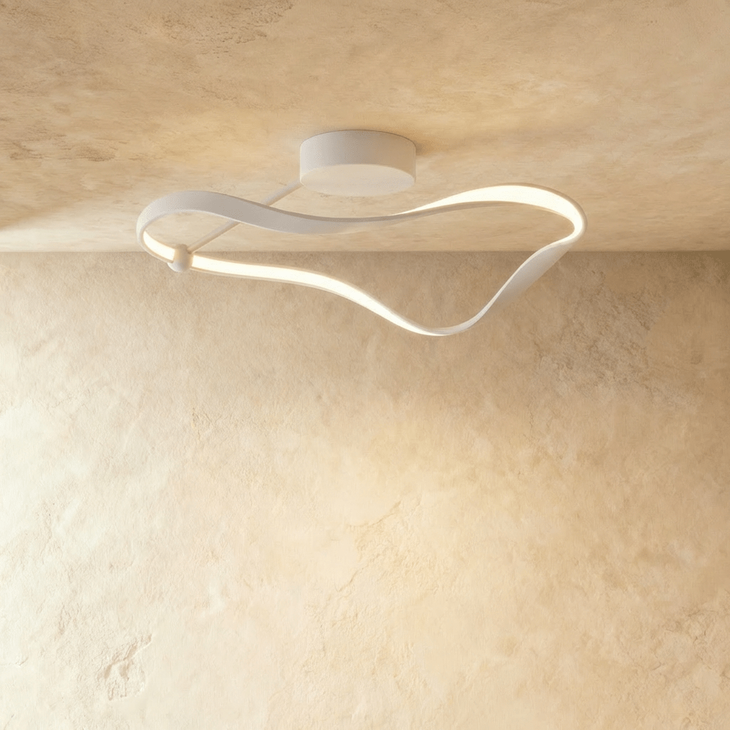 Clérachic white ceiling light formed as a twisting ribbon of aluminium with a soft glowing LED edge, mounted on a limewashed ceiling.