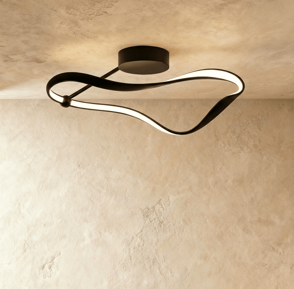 Clérachic mid-length black ribbon ceiling light with a diffused LED glow and a slim support arm, fixed to a textured plaster ceiling.