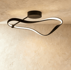 Clérachic longest black ribbon ceiling light, its curved aluminium band lit with a soft LED glow beneath a round canopy.