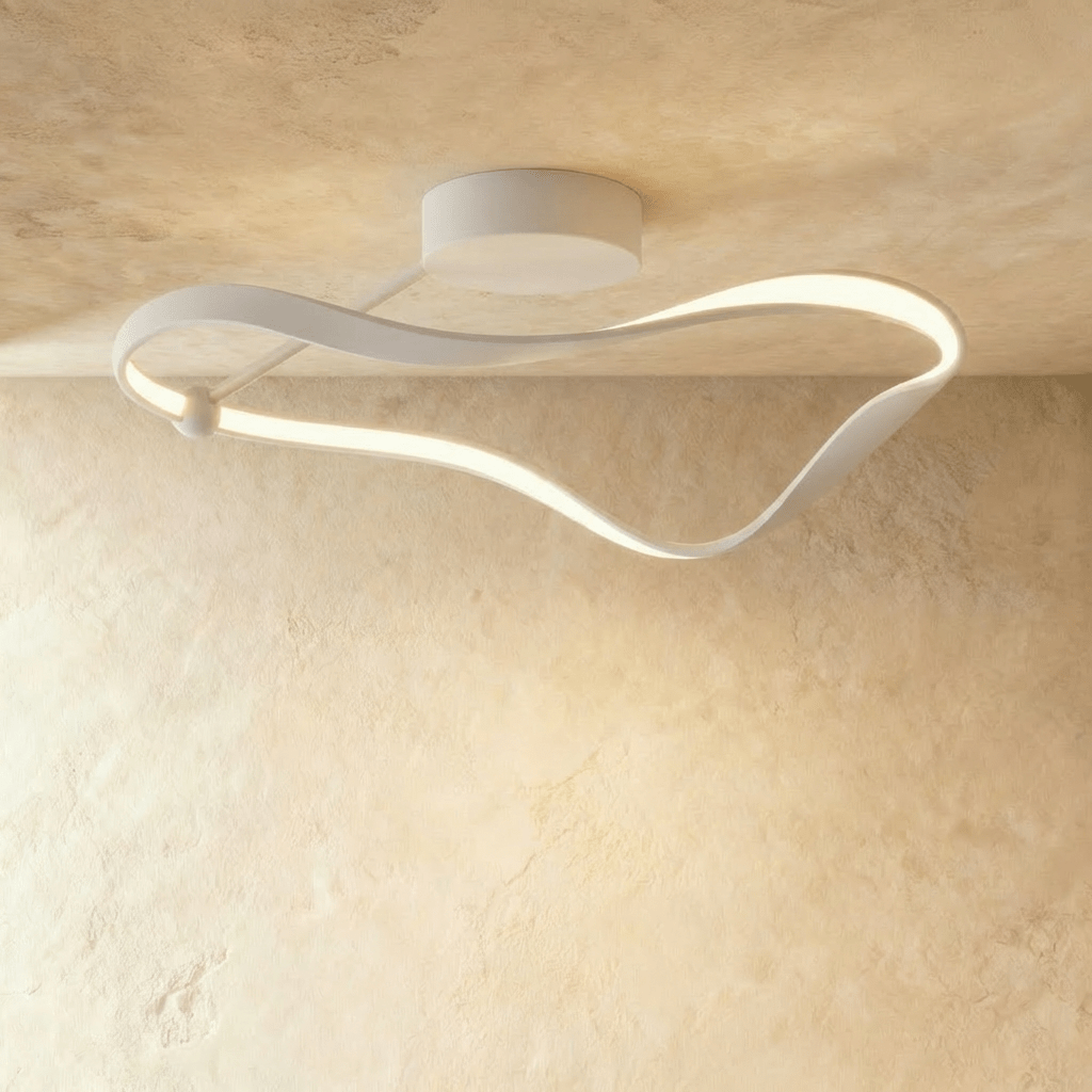 Clérachic longest white ribbon ceiling light, a curved aluminium band with a gentle LED glow, on a limewashed plaster ceiling.