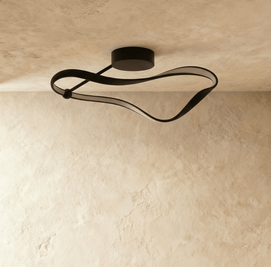 Clérachic black curved ceiling light switched off, showing the matt aluminium band and pale diffuser strip on a plaster ceiling.