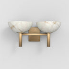 Clérachic Weft wall sconce in brushed brass, twin alabaster bowls resting on a slim bracket against a pale wall.